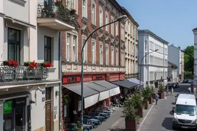 a street with buildings with tables and chairs and a van at Old Market View Premium Standard with AC in Kraków