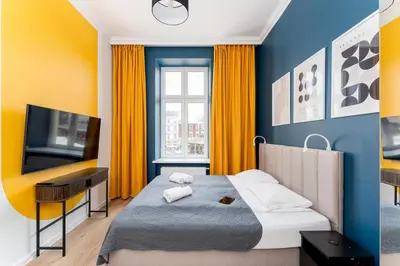 a bedroom with a bed and a flat screen tv at Old Market View Premium Standard with AC in Kraków