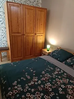 a bedroom with a bed and a wooden cabinet at Apartament 1 blisko Energylandii in Zator