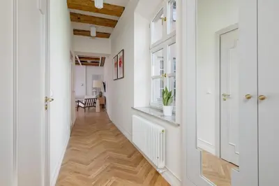 a hallway with white walls and wooden floors at Modern apartment in the heart of the Old Town in Kraków