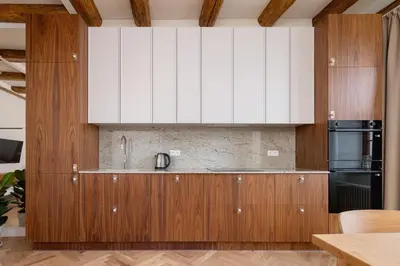 a kitchen with white cabinets and a black refrigerator at Modern apartment in the heart of the Old Town in Kraków
