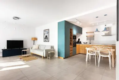 a kitchen and living room with a couch and a table at Przestronny apartament PARKING by NEARTOpl in Kraków