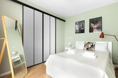 a bedroom with a white bed and a mirror at Przestronny apartament PARKING by NEARTOpl in Kraków