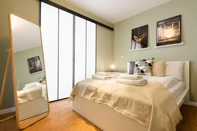 a bedroom with a large bed and a mirror at Przestronny apartament PARKING by NEARTOpl in Kraków