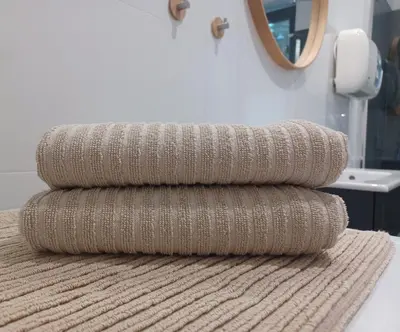 a stack of towels sitting on top of a bathroom rug at Apartament Parkowa 8 in Myślenice