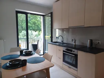 a kitchen with a wooden table and a kitchen with at Apartament Parkowa 8 in Myślenice