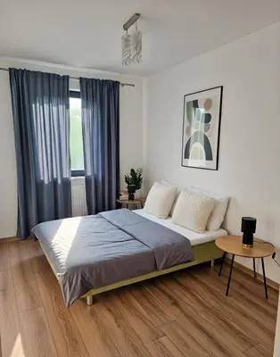 a bedroom with a bed and a table at Apartament Ruczaj - Parking & Self Check-in in Kraków