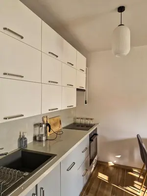 a kitchen with white cabinets and a stove top oven at Apartament Ruczaj - Parking & Self Check-in in Kraków