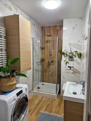 a bathroom with a shower and a washing machine at Apartament Ruczaj - Parking & Self Check-in in Kraków