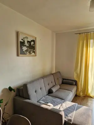 a living room with a couch and a yellow curtain at Apartament Ruczaj - Parking & Self Check-in in Kraków