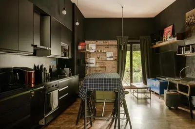 a kitchen with black cabinets and a table with a checkered table cloth at Premium Black Apartment Krakow Center with Parking in Kraków