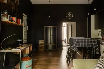 a kitchen with black walls and a table and a clock at Premium Black Apartment Krakow Center with Parking in Kraków