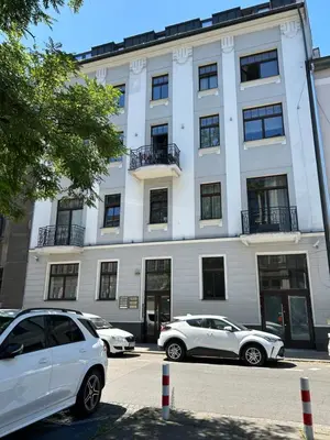 two white cars parked in front of a building at Premium Black Apartment Krakow Center with Parking in Kraków