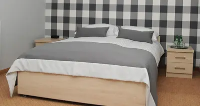 a bedroom with a large bed and a checkered wall at Hotel Klaudia in Juszczyn