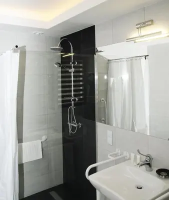 a bathroom with a sink and a shower at Hotel Klaudia in Juszczyn