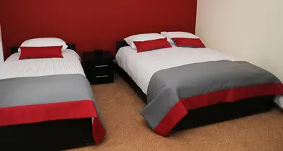 two beds in a room with red and white at Hotel Klaudia in Juszczyn