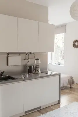 a kitchen with white cabinets and a sink at Quiet Studio in the heart of Kazimierz AC in Kraków