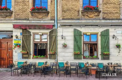 a group of tables and chairs in front of a building at Quiet Studio in the heart of Kazimierz AC in Kraków