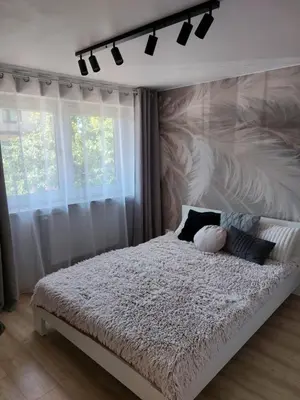 a bedroom with a white bed with a large wall at Wieliczka4You in Wieliczka