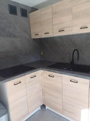 a kitchen with wooden cabinets and a sink at Wieliczka4You in Wieliczka