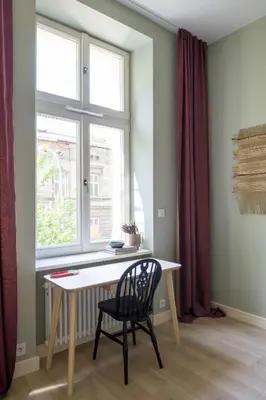 a table and a chair in a room with a window at lovely place, modern design, historic townhouse in Kraków