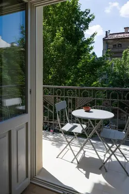 a table and chairs on a balcony with a window at lovely place, modern design, historic townhouse in Kraków