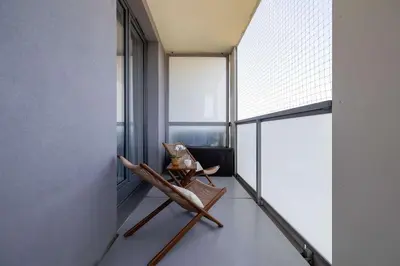 a room with a chair and a large window at Fabryczna Modern Apartment with Balcony & Parking in Cracow by Noclegi Renters in Kraków