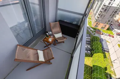 a balcony with two chairs and a bench on a building at Fabryczna Modern Apartment with Balcony & Parking in Cracow by Noclegi Renters in Kraków