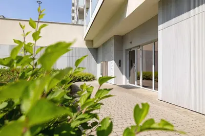 an external view of a building with plants in the foreground at Fabryczna Modern Apartment with Balcony & Parking in Cracow by Noclegi Renters in Kraków