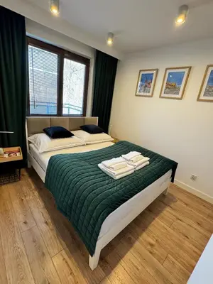 a bedroom with a bed with a green blanket at Mon Rêve in Kraków
