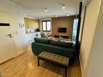 a living room with a green couch and a table at Mon Rêve in Kraków