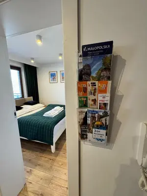 a bedroom with a bed and a refrigerator with magazines at Mon Rêve in Kraków
