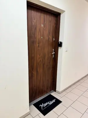 a wooden door with a welcome mat in front of it at Mon Rêve in Kraków