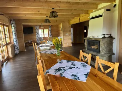 a dining room with a table and a fireplace at Mecenasówka in Zawoja