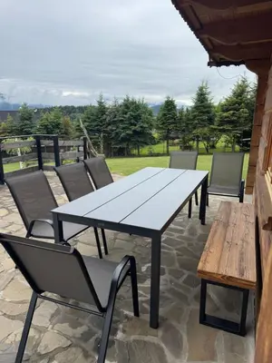 a picnic table and chairs on a patio at Mecenasówka in Zawoja