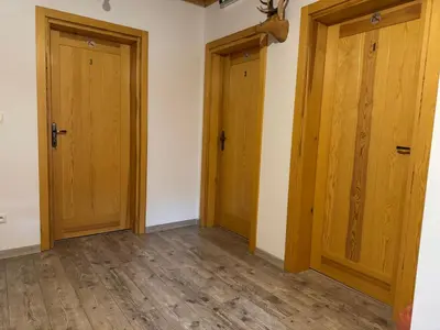 two doors in an empty room with wooden floors at Mecenasówka in Zawoja
