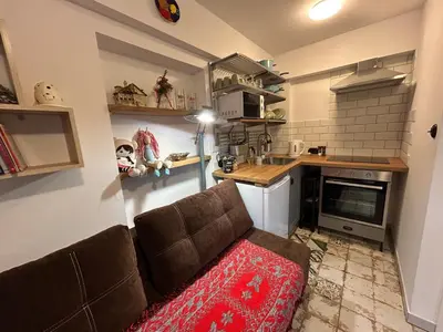 a living room with a couch and a kitchen at W górach nad strumieniem in Bieńkówka