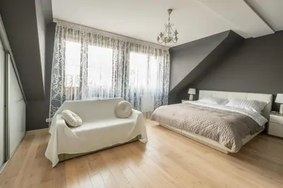 a bedroom with a white bed and a chair at Apartament na Skarpie in Rabka