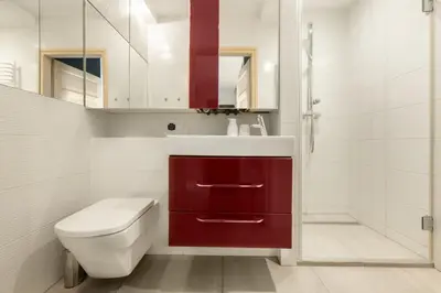a bathroom with a white toilet and a red cabinet at Apartament na Skarpie in Rabka