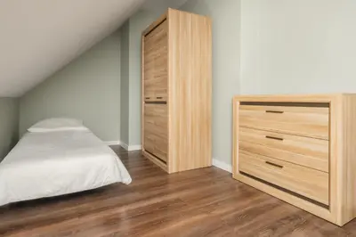 a bedroom with a bed and a wooden dresser at Apartament na Skarpie in Rabka