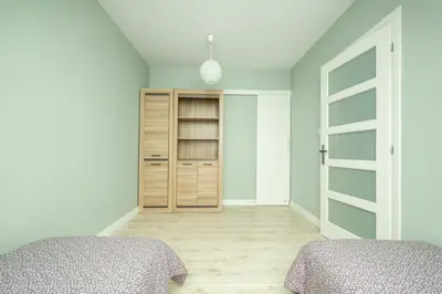 a bedroom with two beds and a closet at Apartament na Skarpie in Rabka
