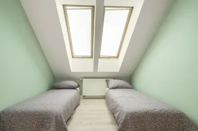 two beds in a room with two windows at Apartament na Skarpie in Rabka