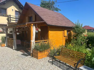 a small house with a bench in front of it at Sosnowy Domek in Zator