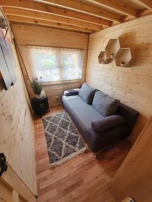 a living room with a couch in a wooden room at Sosnowy Domek in Zator