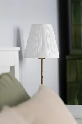 a white lamp sitting on top of a bed at ANTA Apartments Warszawska in Kraków