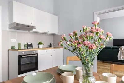 a kitchen with a table with a vase of flowers at ANTA Apartments Warszawska in Kraków
