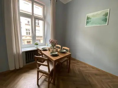 a dining room with a table and chairs and a window at ANTA Apartments Warszawska in Kraków