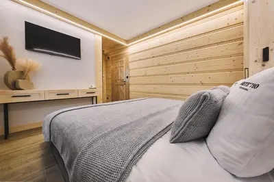 a bedroom with a bed with a wooden wall at Arete' 710 Stryszawa in Stryszawa