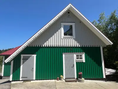 a green and white building with a window at Dom pod Świerczkiem in Słopnice