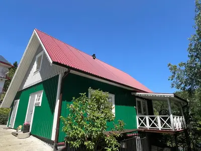 a green and white house with a red roof at Dom pod Świerczkiem in Słopnice